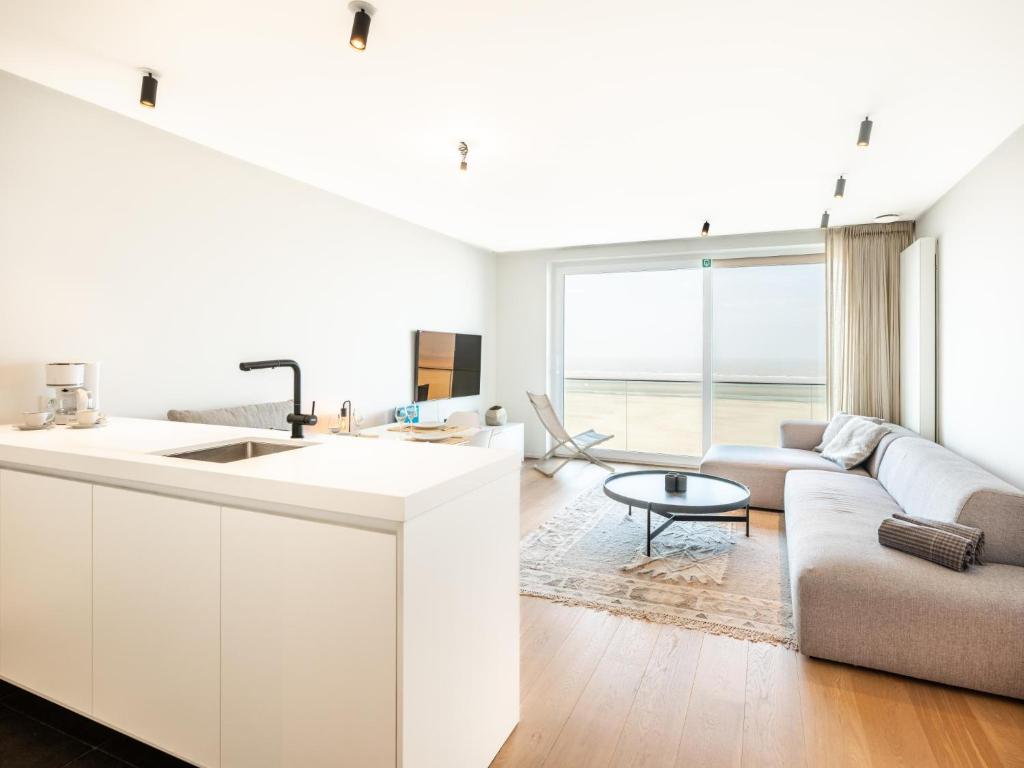 a white kitchen and living room with a couch at Sable dArgent in Galopen