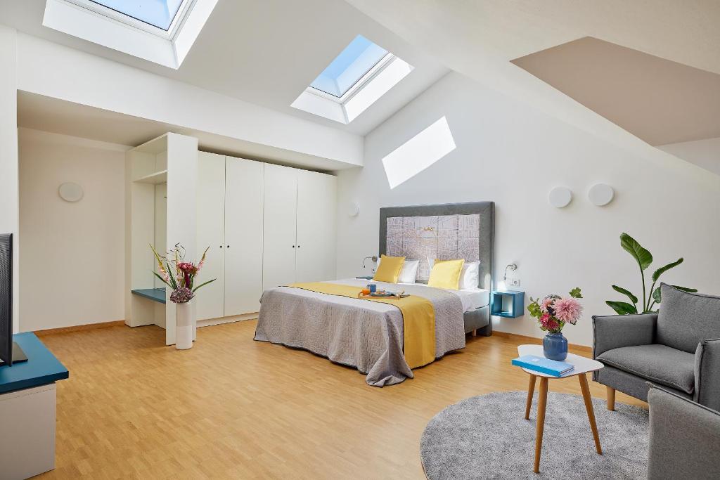 a bedroom with a bed and a couch at SEEGER Living Premium Downtown in Karlsruhe