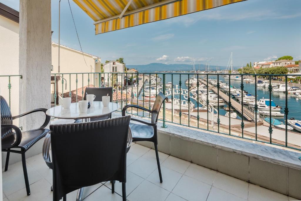 a balcony with a table and chairs and a view of a marina at Apartments Obala in Malinska