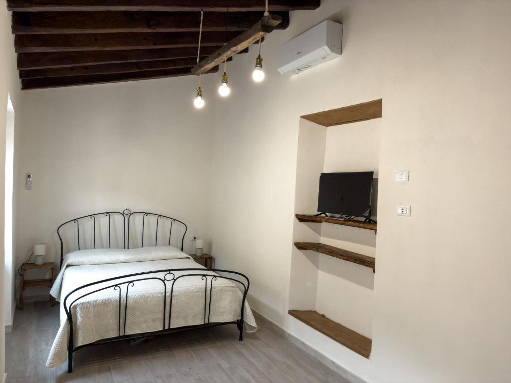 ein Schlafzimmer mit einem Bett und einem Fernseher an der Wand in der Unterkunft Zia Lina in Crevari