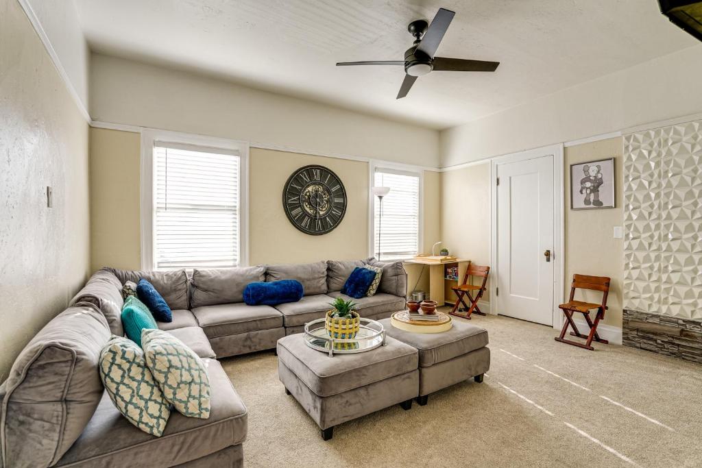 a living room with a couch and a clock on the wall at Pet-Friendly Condo Less Than 2 Mi to Alameda Beach! in Alameda