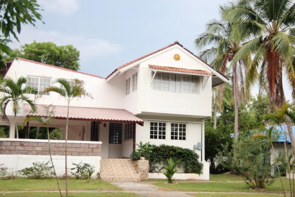 een wit huis met palmbomen ervoor bij Casa Kitesurf - 1 Min a Playa, Pool, BBQ in Chame