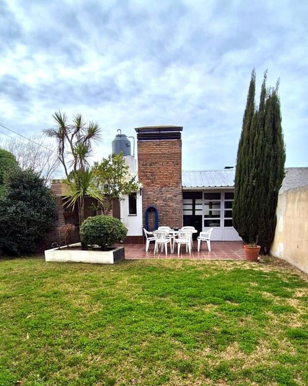 una casa con mesa y sillas en un patio en Casa ideal familias-8 personas a 3 cuadras del mar, en Monte Hermoso