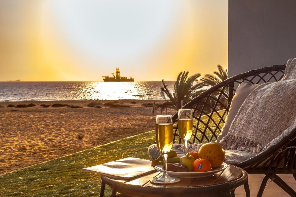 a table with two glasses of champagne on the beach at Dolphin View Beach House in Walvis Bay