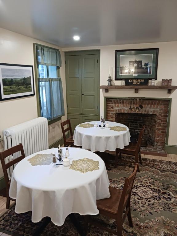 two tables and chairs in a room with a fireplace at Langdon Hill House Felty Room in Gettysburg
