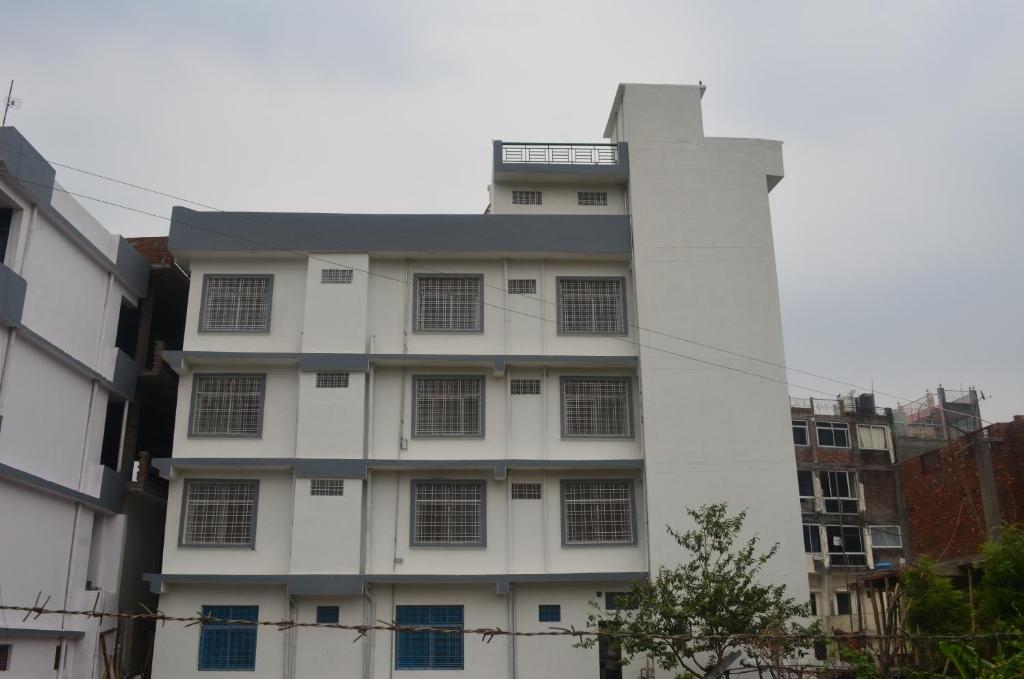un edificio blanco con muchas ventanas a un lado. en The Village en Rishīkesh