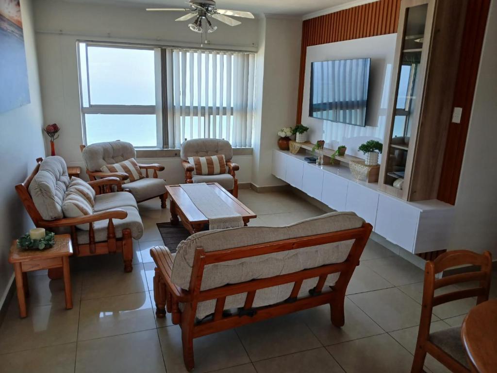 a living room with several chairs and a table at Oceanview Holiday Apartments in Amanzimtoti