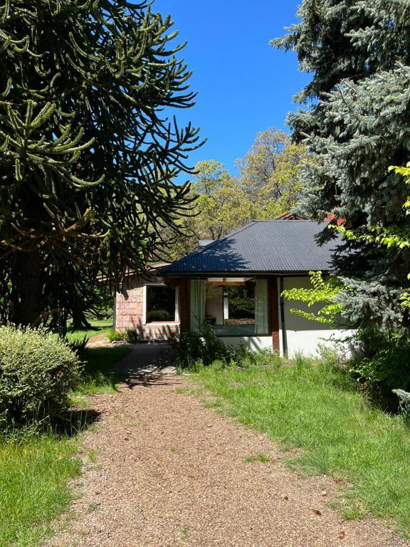 a small house with a gravel road leading to it at Huala Hosteria in Lago Puelo