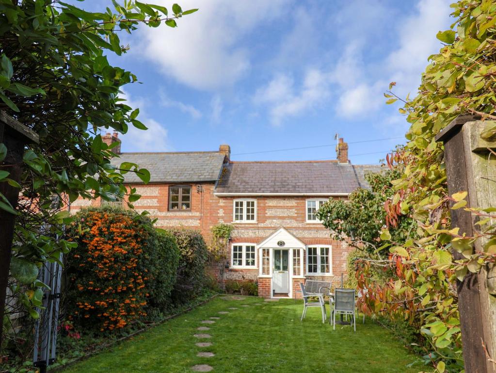 an exterior view of a brick house with a yard at Poppy Cottage in Charlton Marshall