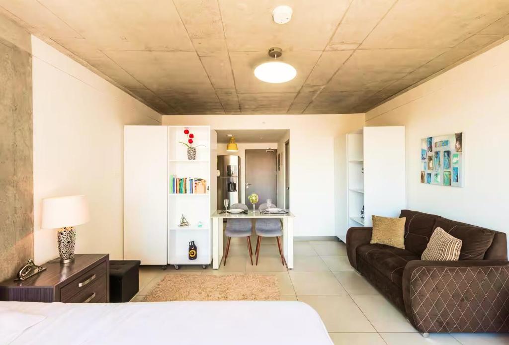 una sala de estar con un sofá y una mesa en Studio Panorámico en la Ciudad, en Curridabat