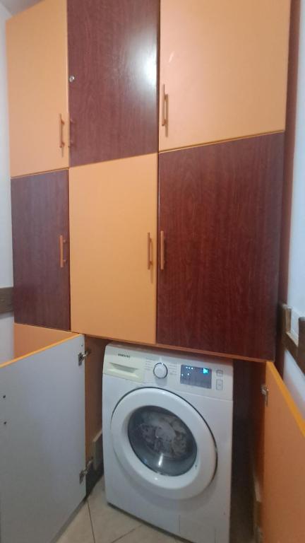 a washing machine in a room with wooden cabinets at Golem Green Retreat in Golem