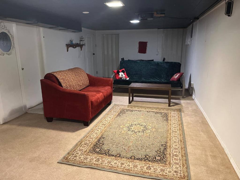 a living room with a red chair and a couch at Hilltop Orchard Guest Suite with Scenic View in Yakima