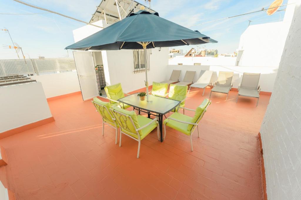 a patio with a table and chairs and an umbrella at Casa Pepi Sánchez Conil in Conil de la Frontera