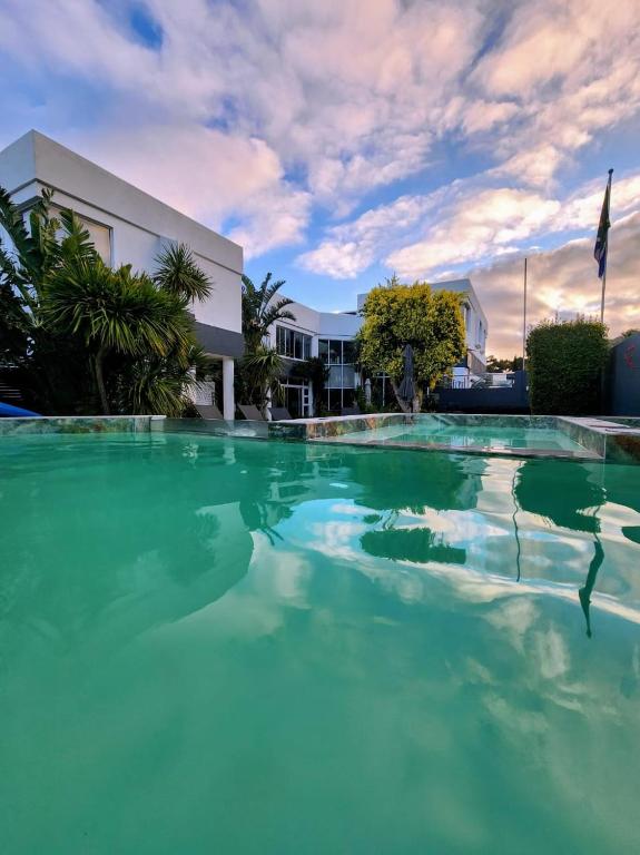 a pool of green water in front of a building at Hermanus Manor in Hermanus