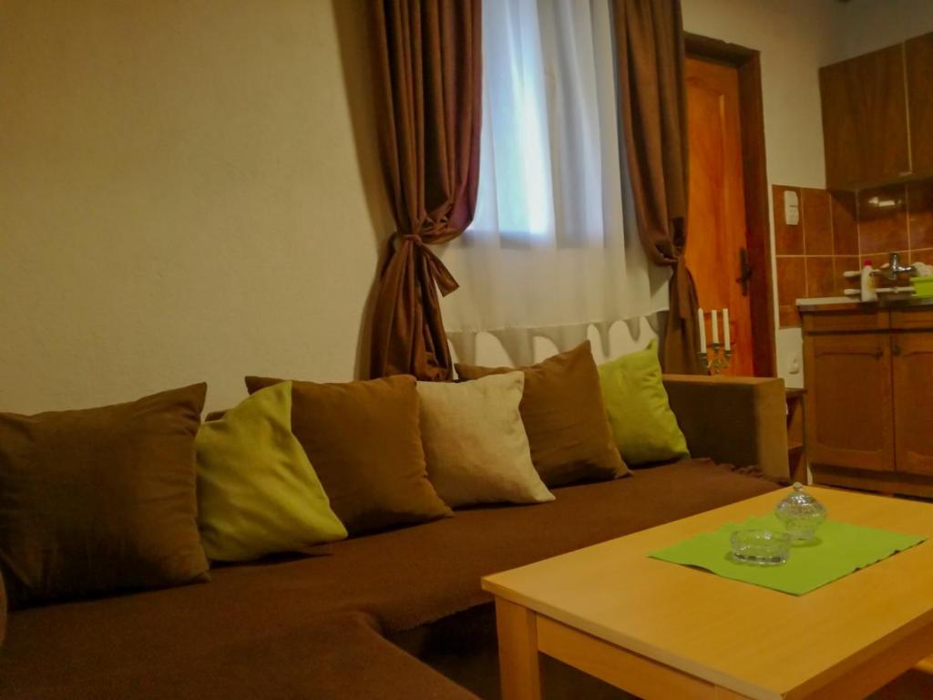 a living room with a couch and a table at Cozy Cabin in Sekulić 