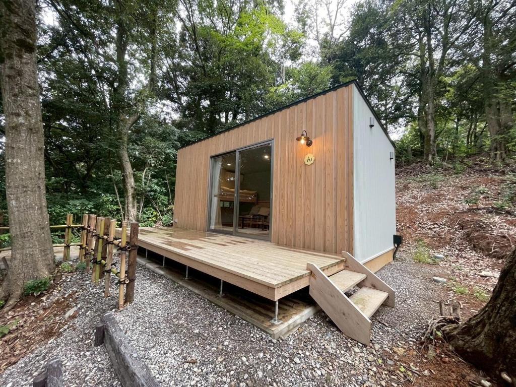 une petite maison avec une terrasse dans les bois dans l'établissement Aiueo no Mori - Vacation STAY 79153v, à Yamashiro