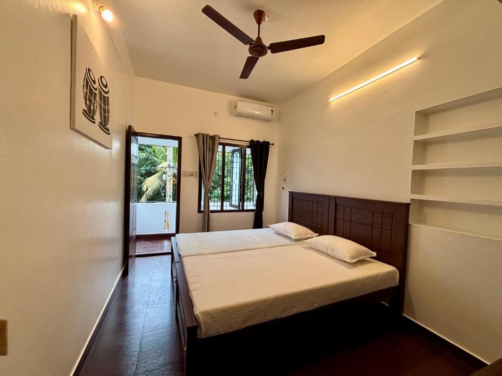 Un dormitorio con una cama y un ventilador de techo. en Fort Grande Stay, en Kochi