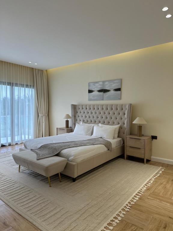 a bedroom with a large bed and a large window at Hatta Valley Lodge in Hatta