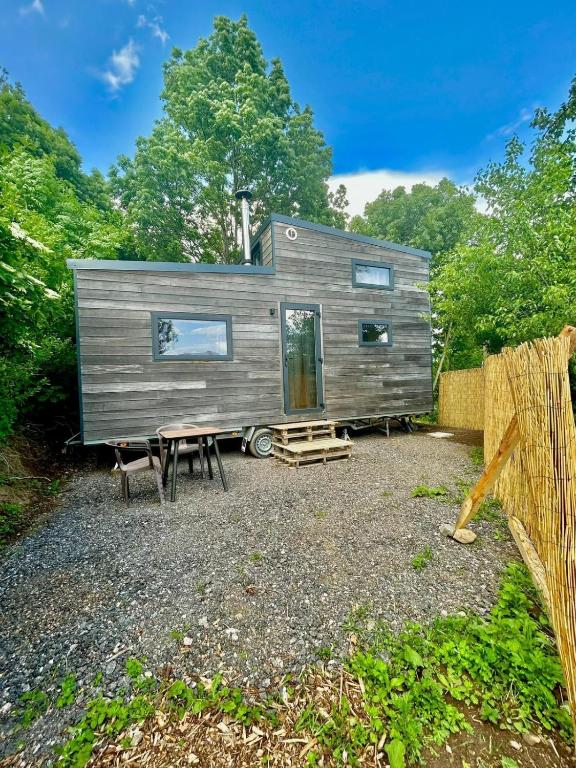 a tiny house sitting on top of a gravel yard at Tiny house chaleureuse en Matheysine in Saint-Jean-de-Vaux
