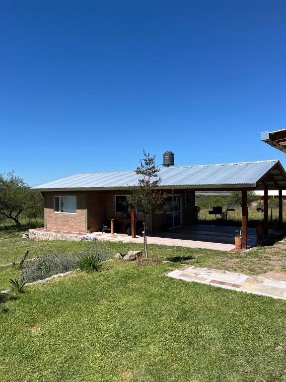 a house with a metal roof and a yard at Terraza de Amancay in Villa Amancay