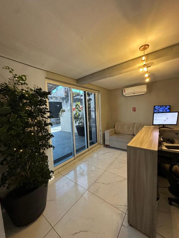 a living room with a couch and a potted plant at Por do Sol Praia Hotel in Fortaleza