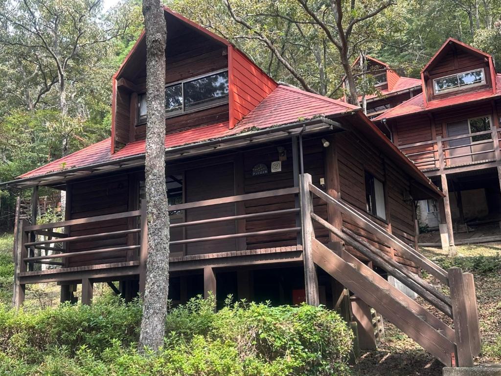 une cabane dans les bois avec un toit rouge dans l'établissement Sky Lodge Gingamura - Vacation STAY 84333v, à Shironita