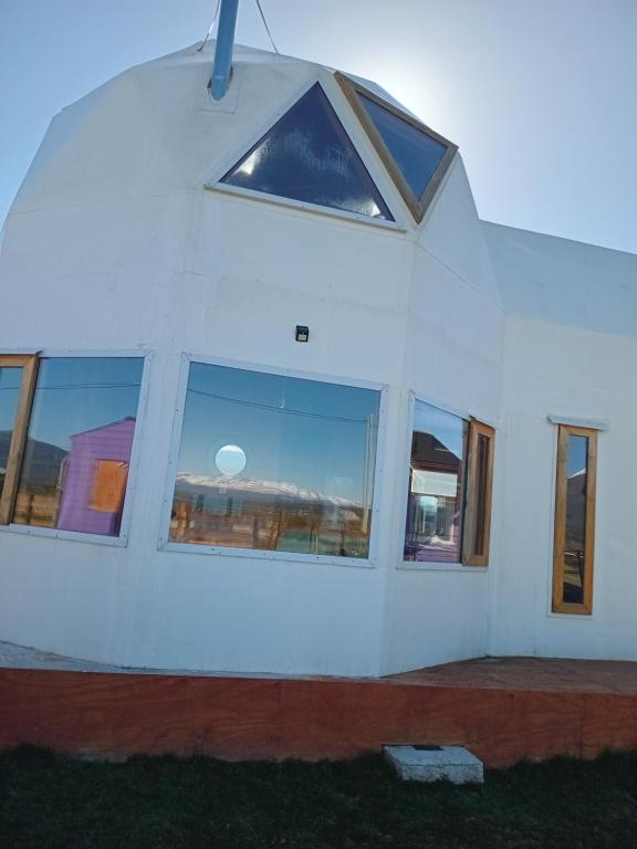 a white building with a window on the side of it at La Morada del Lago in Tolhuin