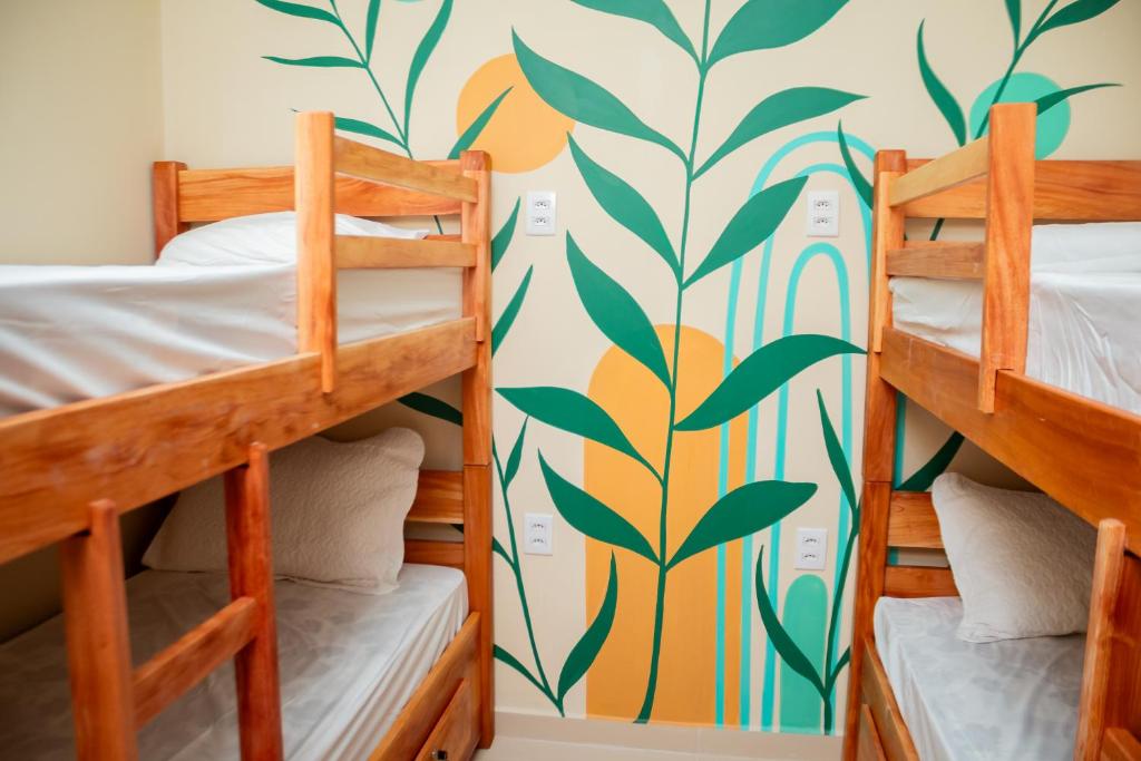 a bedroom with bunk beds and a wall with a mural at Eco Hotel Mãe De Sagui in Castanhal