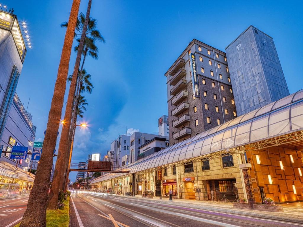 a city street with palm trees and tall buildings at APA Hotel Miyazaki Eki Tachibanadori in Miyazaki