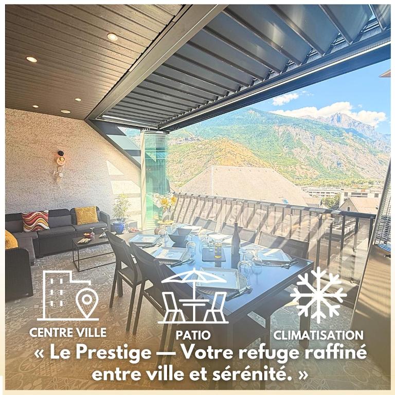 a patio with a table and chairs and a couch at Prestige Hyper Centre Veranda Climatisation in Saint-Jean-de-Maurienne