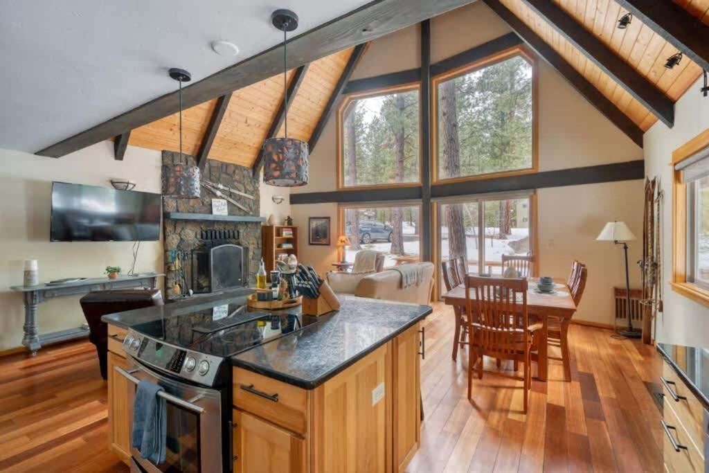 a kitchen and living room with wooden floors and windows at Spring Home 6 - Cozy 4BR Cabin in Black Butte Ranch w Fireplace in Black Butte Ranch