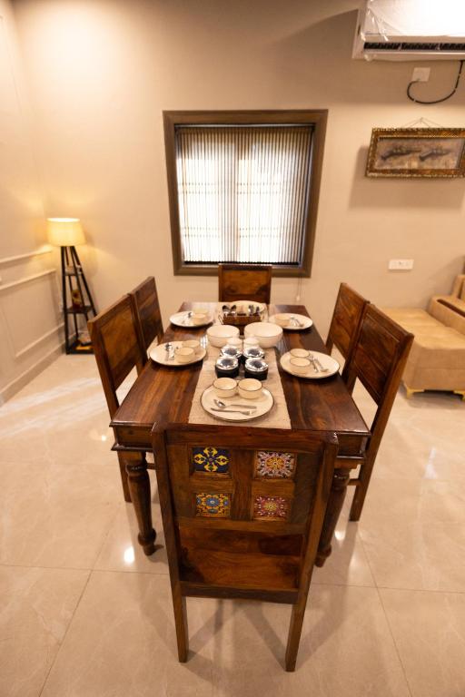 a wooden table and chairs in a living room at Annapurna Home in Noida