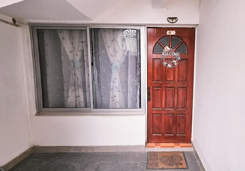 a wooden door with a window in a building at Apart-Hotel Katari in Arica