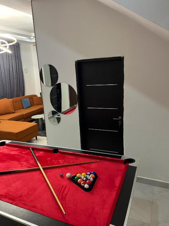 a pool table with a cue in a living room at Roak Hotels and Apartments in Abuja