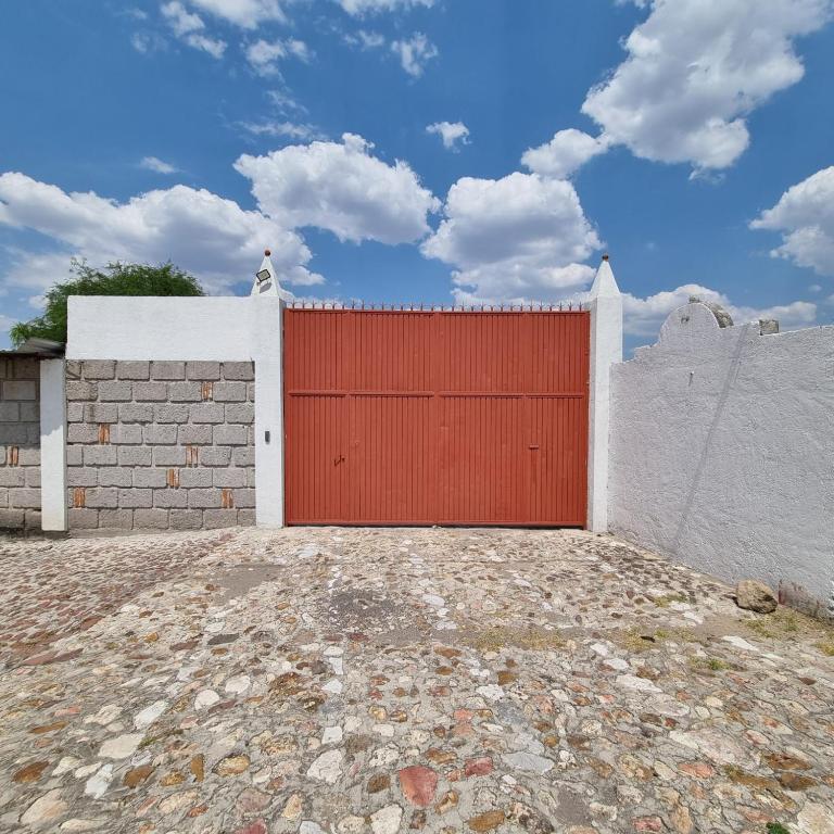a red garage door on a white wall at Casa Müi in Tequisquiapan
