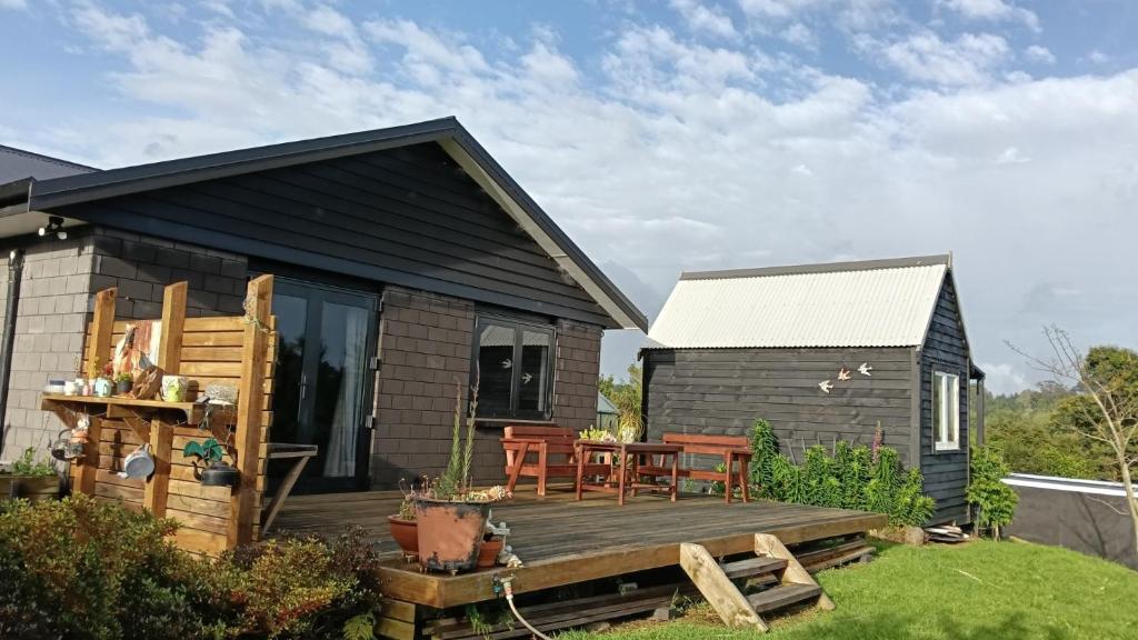 a tiny house with a deck and a table at Bordeaux Retreat in Te Kauwhata