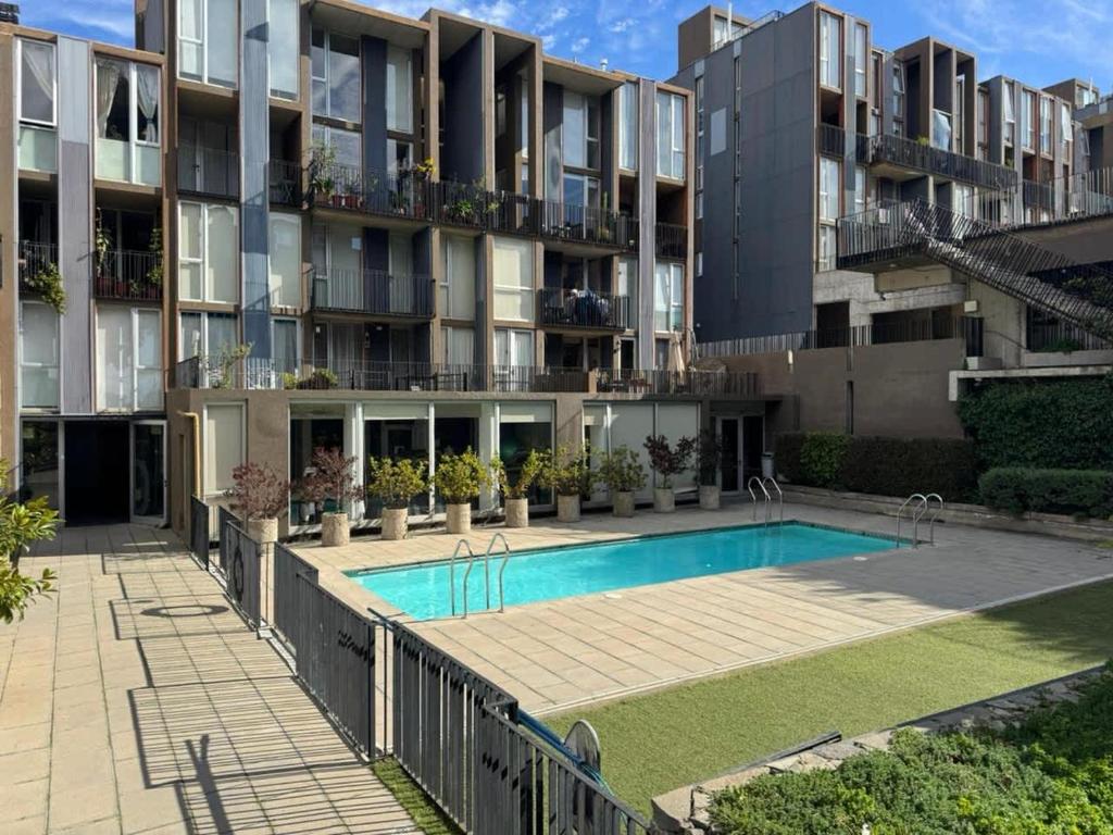 ein Apartmentkomplex mit einem Swimmingpool vor einem Gebäude in der Unterkunft HOM I Loft en mejor zona de Valparaiso 2PAX in Valparaíso
