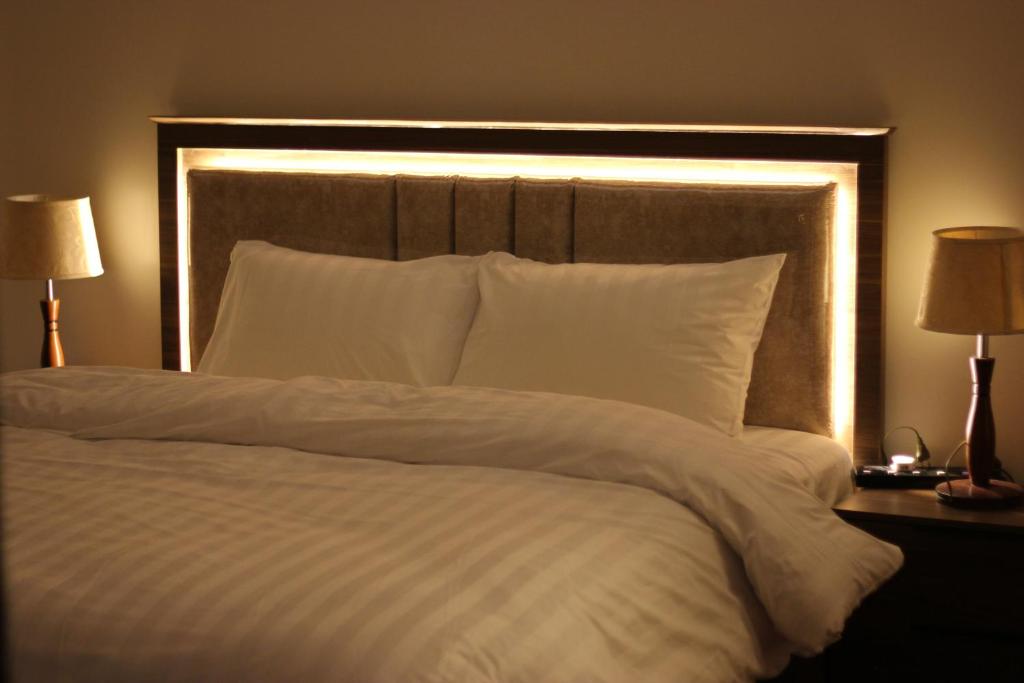 ein großes Bett mit weißen Laken und Kissen in der Unterkunft Luna Luxury Apartment in Medina