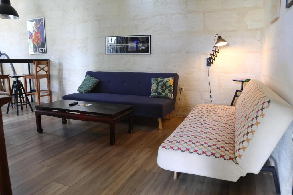 a living room with a blue couch and a table at Maison T3 - 2 chambres lits doubles in Lormont