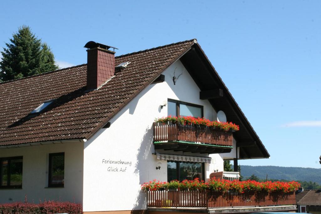 ein weißes Gebäude mit Blumenkästen drauf in der Unterkunft Ferienwohnung Glück Auf in Walkenried