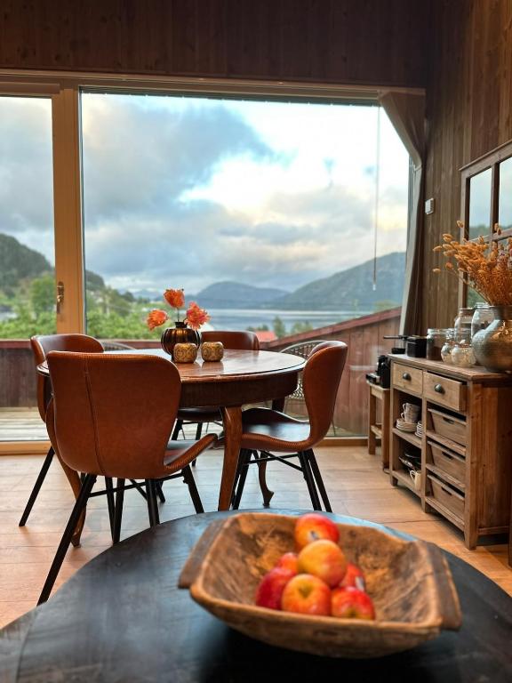 a room with a table with a bowl of fruit on it at Architectural gem with fjord view in Holmedal