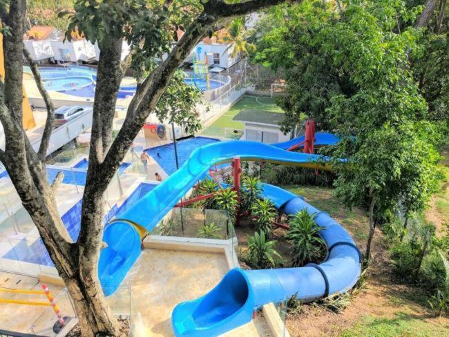 un parc aquatique avec un toboggan bleu dans l'établissement Casa de Verano, à Santa Fe de Antioquia