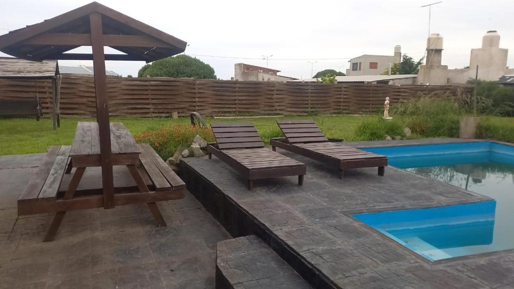 a patio with two benches and an umbrella next to a pool at Alma de Colibrí in Mar del Plata