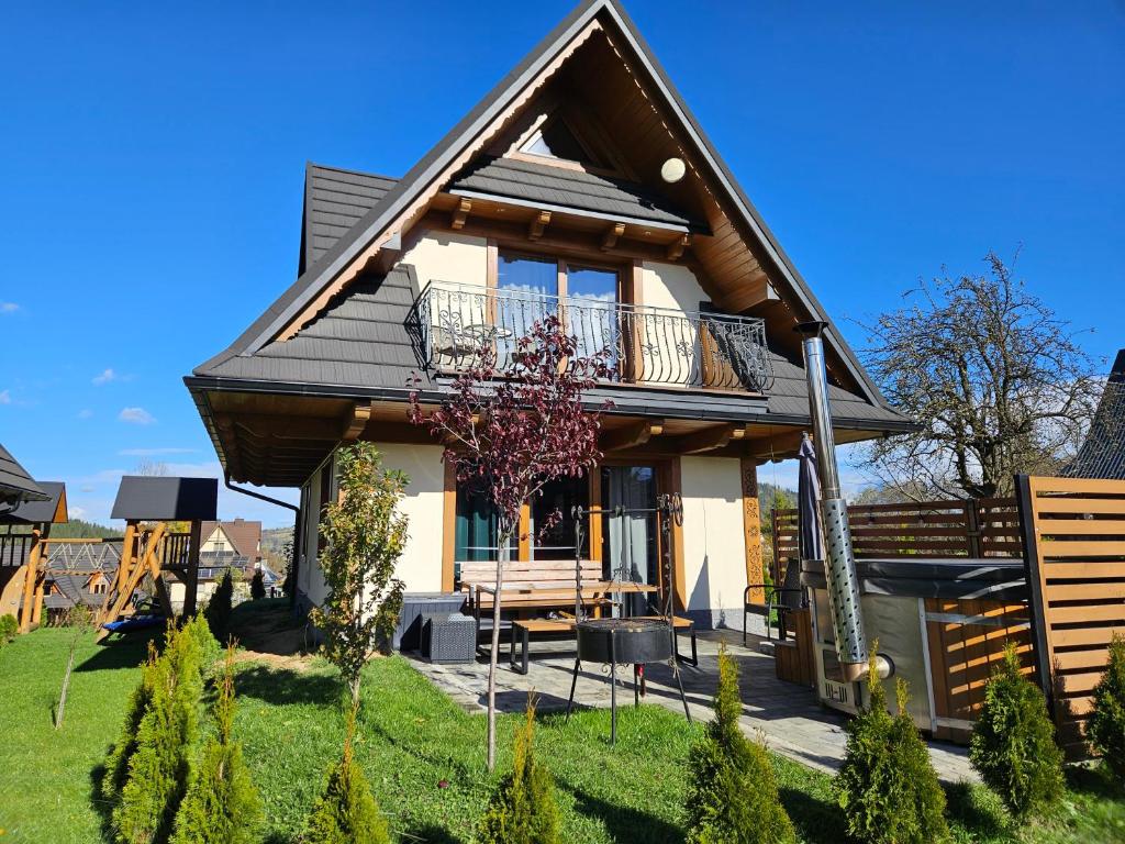 a small house with a gambrel roof at Holne domki in Poronin