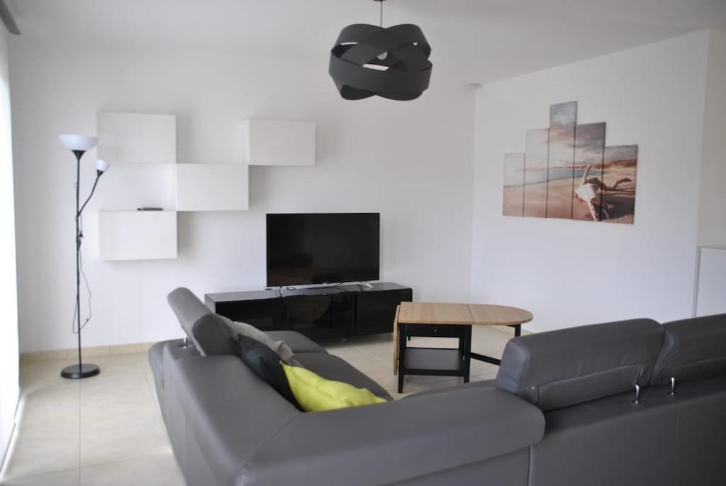 a living room with a couch and a table at Maison Océan Moliets in Moliets-et-Maa