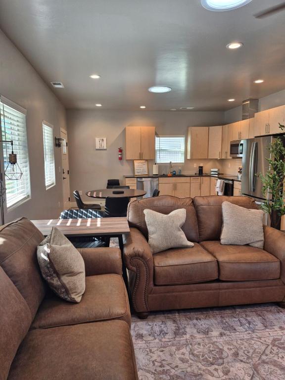 a living room with two brown couches and a kitchen at Bluff 11 Professional Housing in Delta