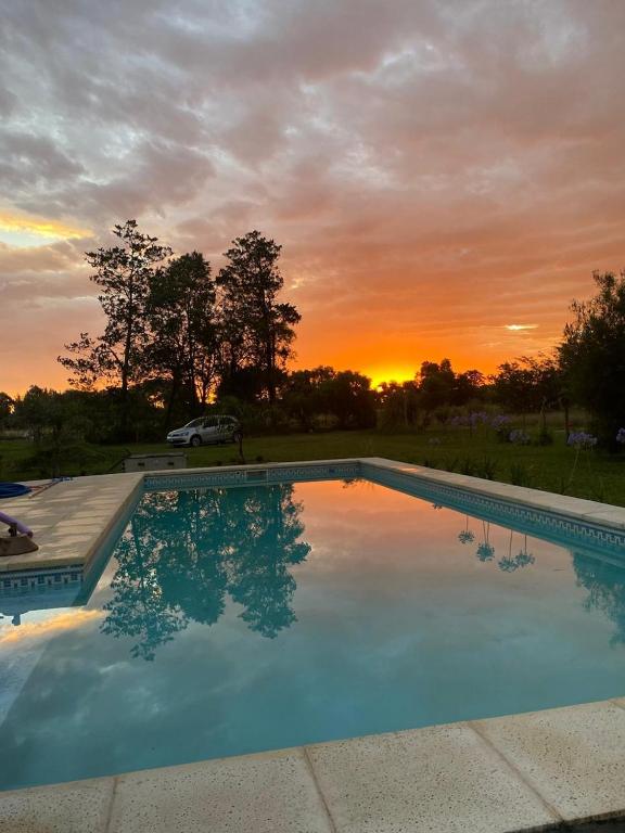 a large swimming pool with a sunset in the background at Las moras saladillo in Saladillo