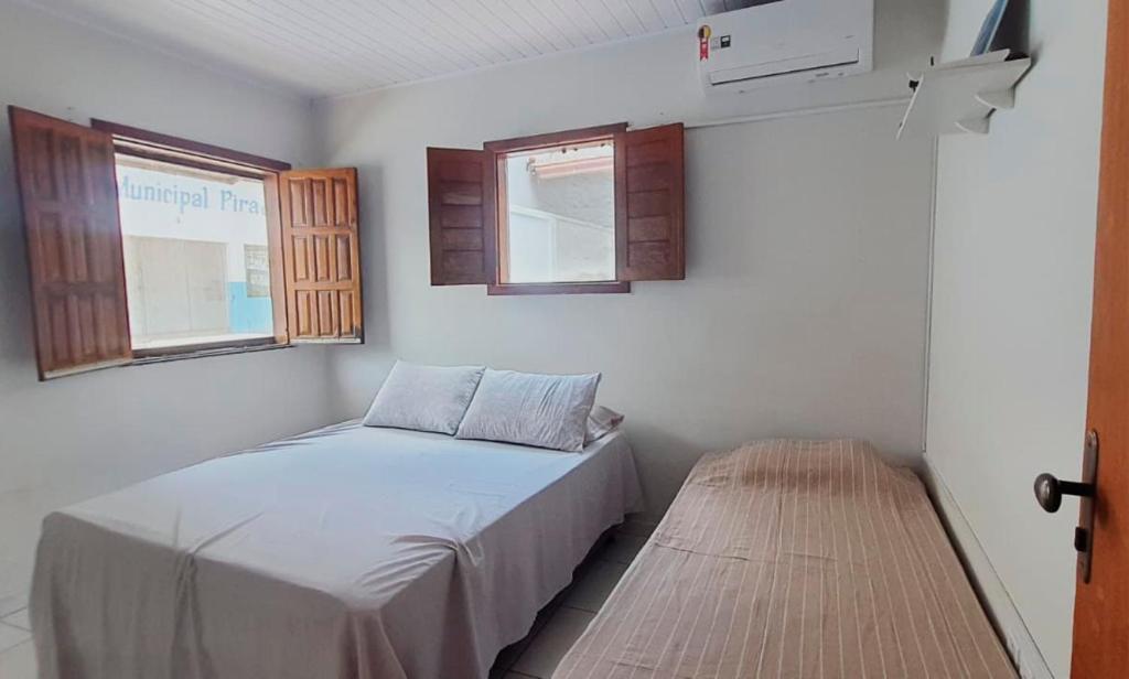 a small bedroom with a bed and a window at Flat Kactus in Itacaré