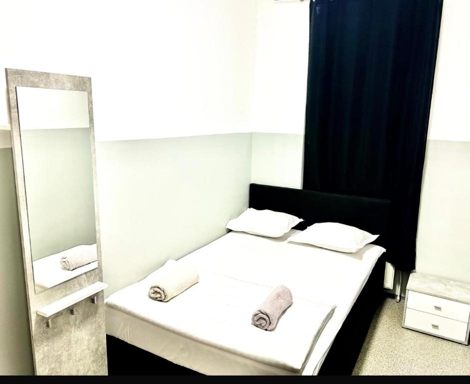 Schlafzimmer mit einem weißen Bett und einem Spiegel in der Unterkunft Privat Room near City Center Wien in Wien