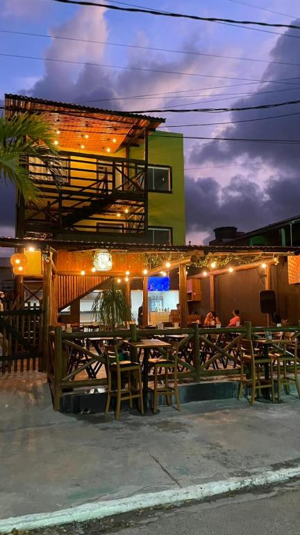 a restaurant with tables and chairs in front of a building at 14 Bis Hospedagem in Arembepe